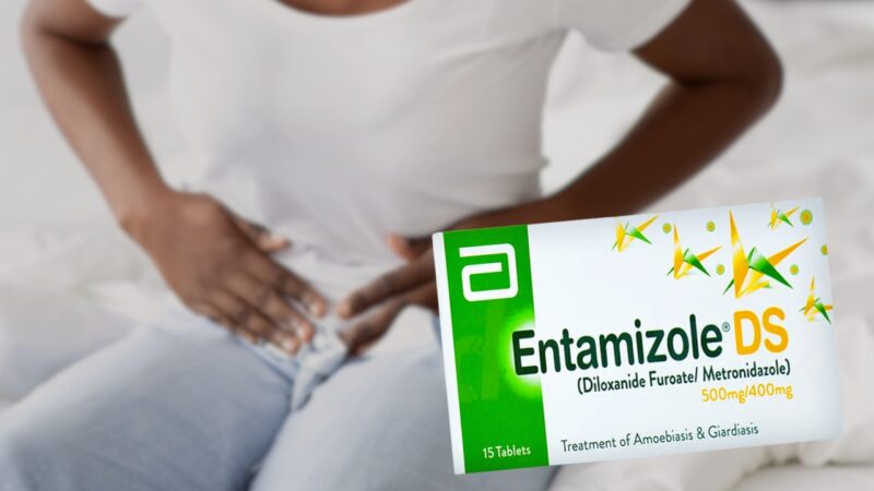 The Image Shows a Person Holding Their Stomach in Discomfort, Alongside a Box of Entamizole, Which Is Used to Treat Stomach Pain