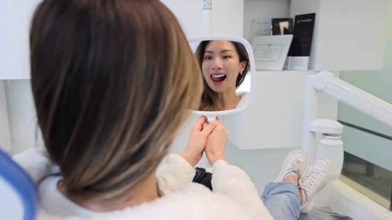 Woman in A Dental Chair Admiring Her Hollywood Smile in Dubai 