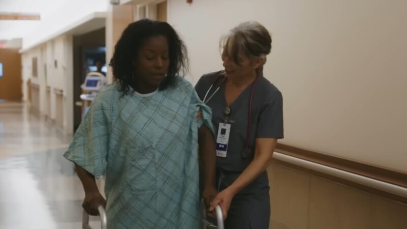 A Nurse Assisting a Patient with A Walker in A Hospital Hallway, Illustrating Patient Care and The Importance of Nursing Support in Recovery