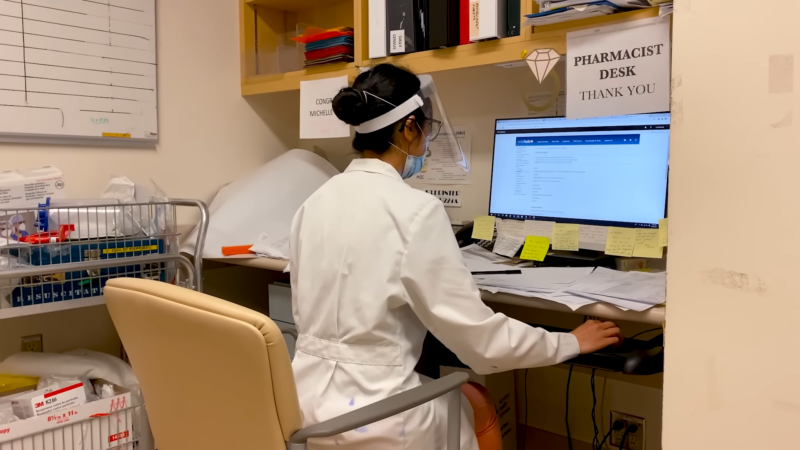 A Pharmacist Sits at A Desk in A Pharmacy Office