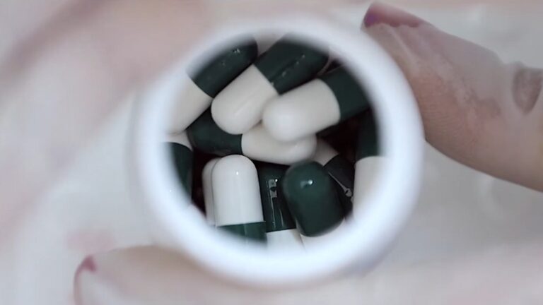 Close-Up of Green and White Capsules in A Bottle, Symbolizing Preparation for A Career in Pharmacy