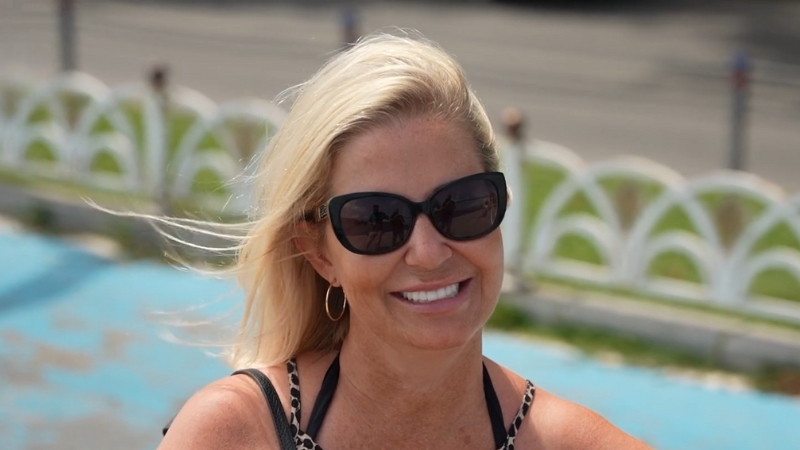 Woman Wearing Sunglasses Showing a Bright Hollywood Smile