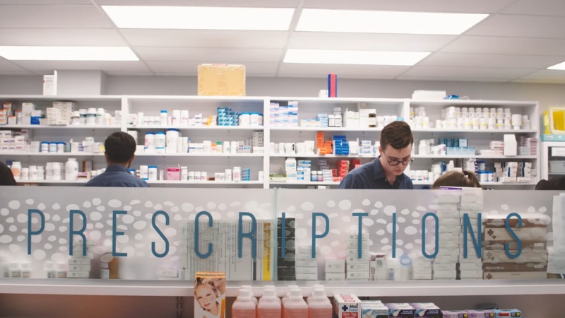 Pharmacists Working Behind the Counter in A Modern Pharmacy