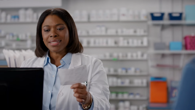 A Pharmacist Reviews a Prescription in A Modern Pharmacy