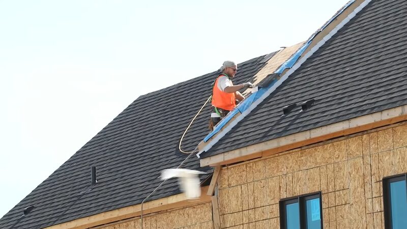 A Roofer Working on A Steep Roof, Demonstrating the Risks of High-Altitude Construction Tasks