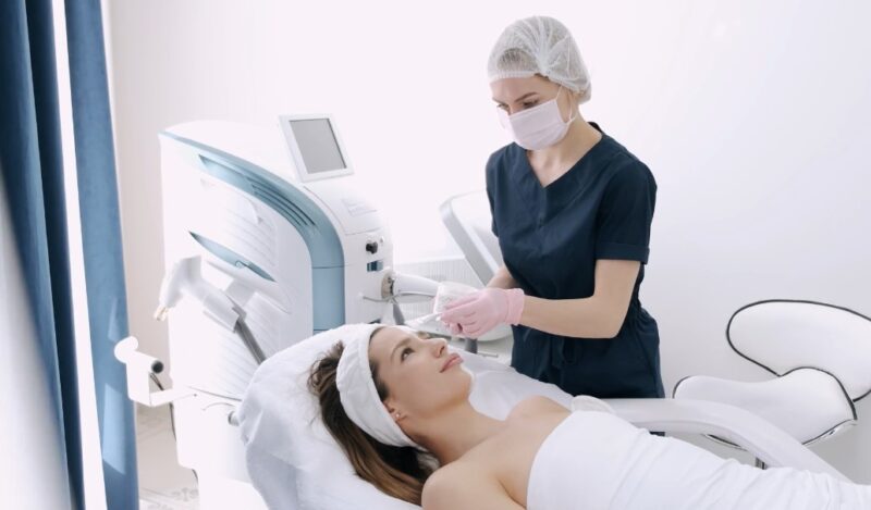 A skilled aesthetician expertly applies a treatment to a patient's face