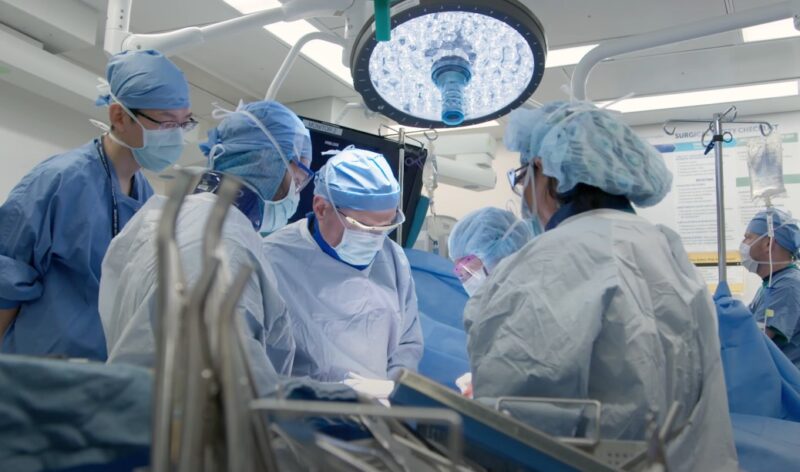 Surgical team in focused action, performing a procedure